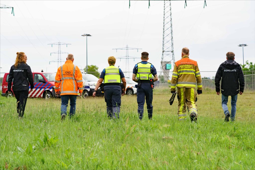 Hulpverleners lopen door veld