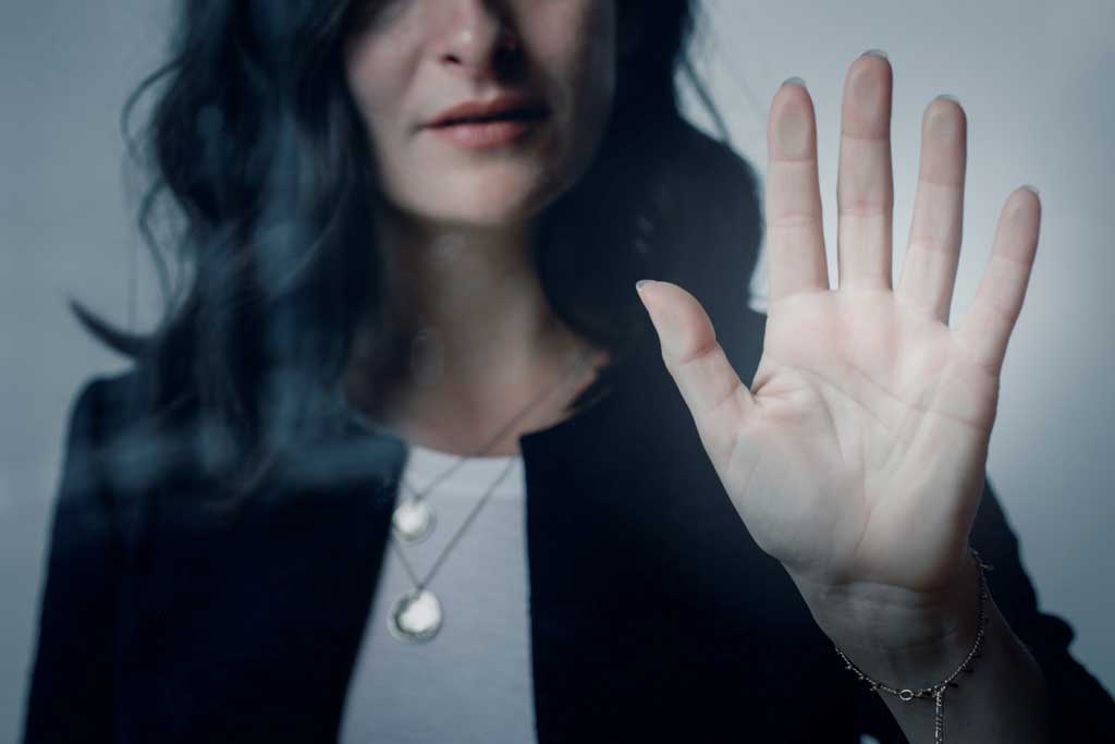 vrouw met hand tegen een raam