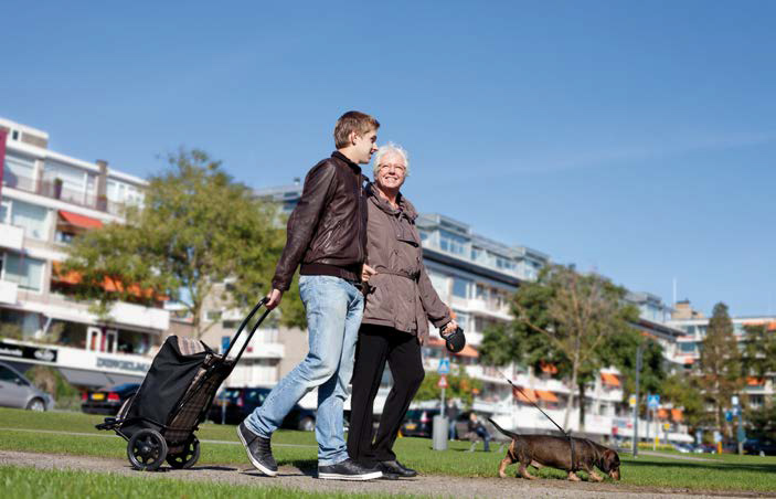 jongeman en oudere vrouw wandelen met hond