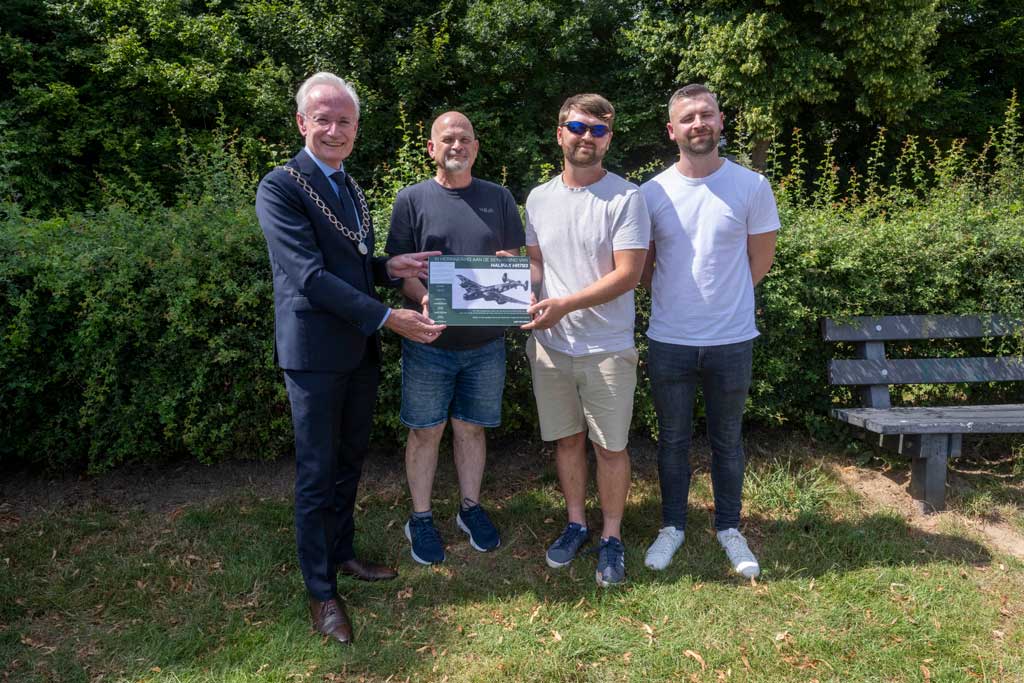 Groepsfoto met burgemeester en familie piloot bij onthulling gedenkplaat Limbricht