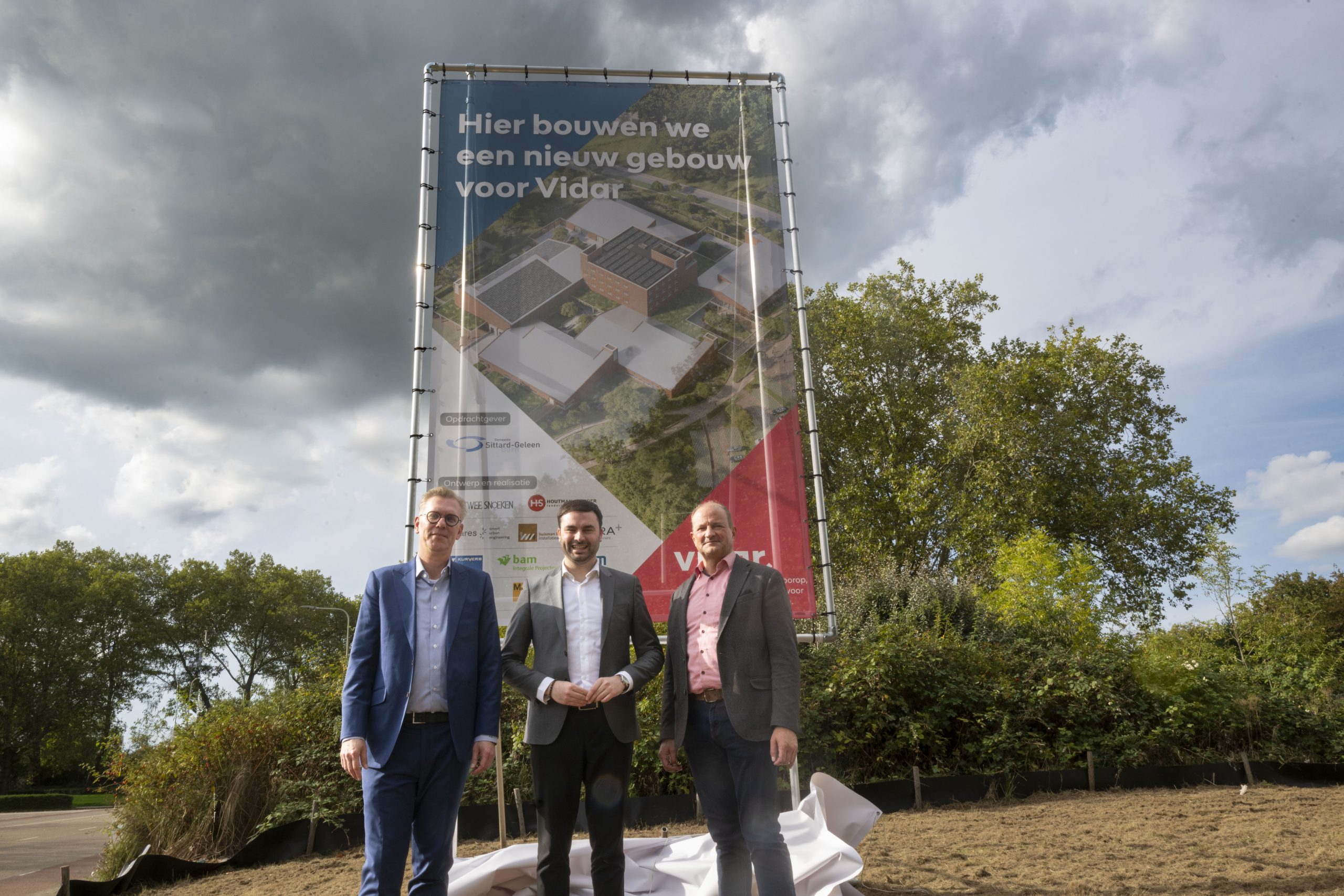 bouwbord met de tekst 'hier bouwen we een nieuw gebouw voor Vidar'.